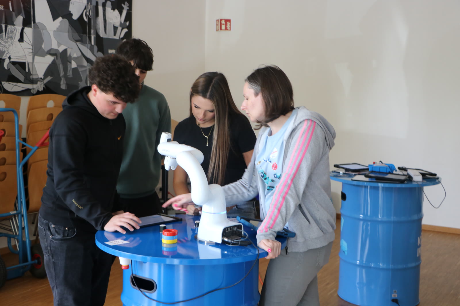 Lernende erproben mit einem Digital-Coach einen Roboterarm an einer Station der Wilhelm-Knapp-Schule Weilburg.