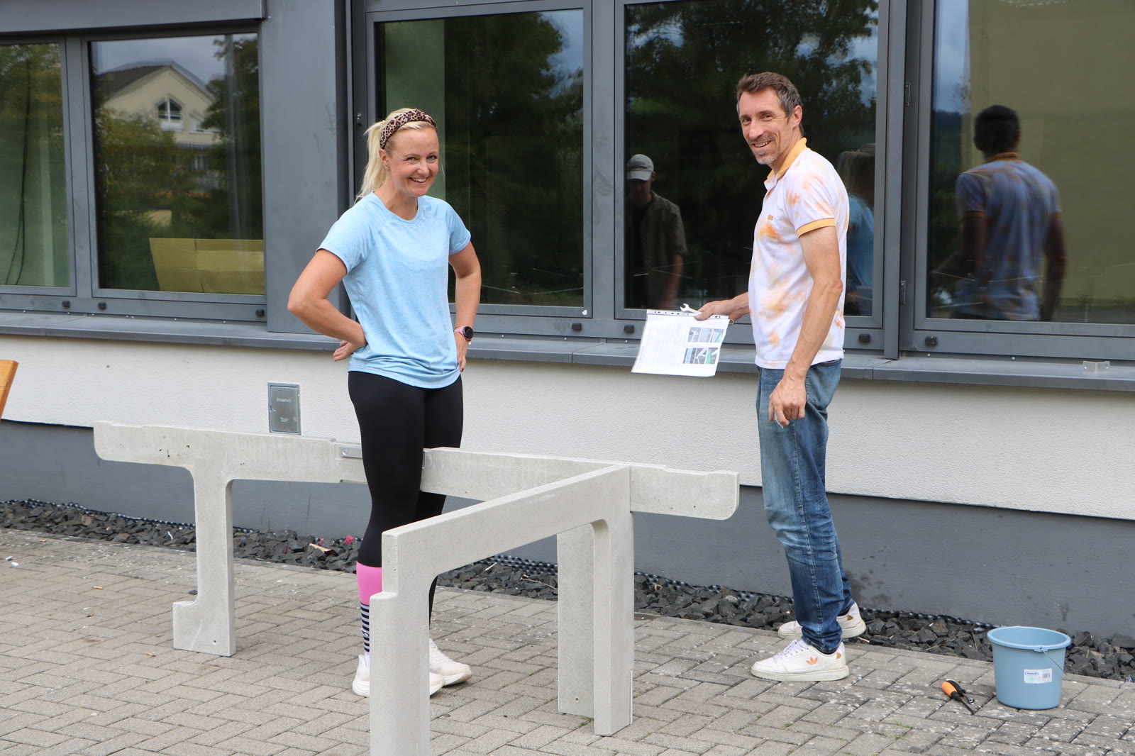 Zwei Lehrkräfte beim Aufbau der neuen Outdoor-Tischtennisplatte auf dem Schulhof der WKS Weilburg.